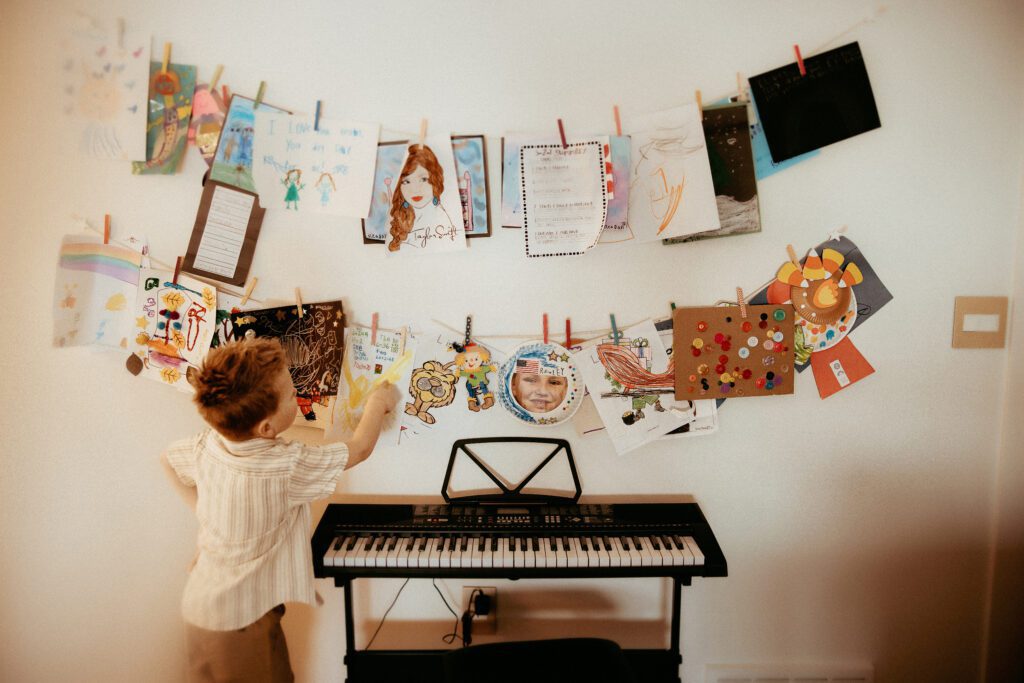 Little boy showing off all of his artwork he's made for his mom and dad.