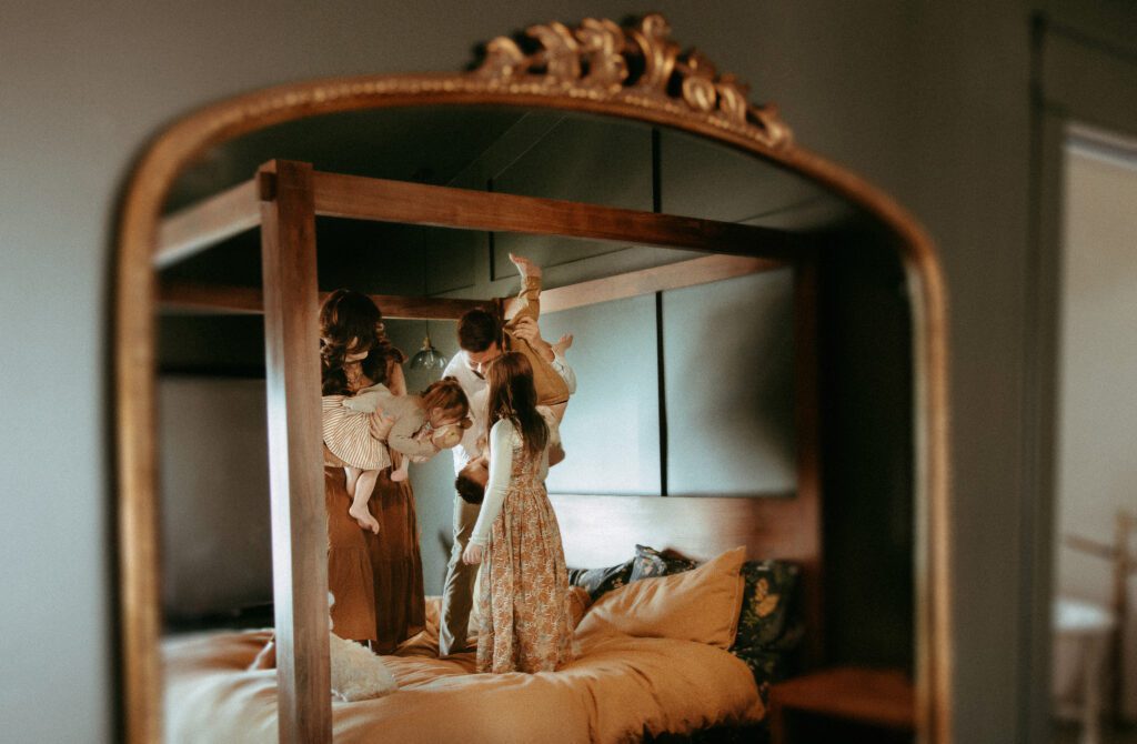 Looking at a reflection through the mirror of a family dancing on the bed.