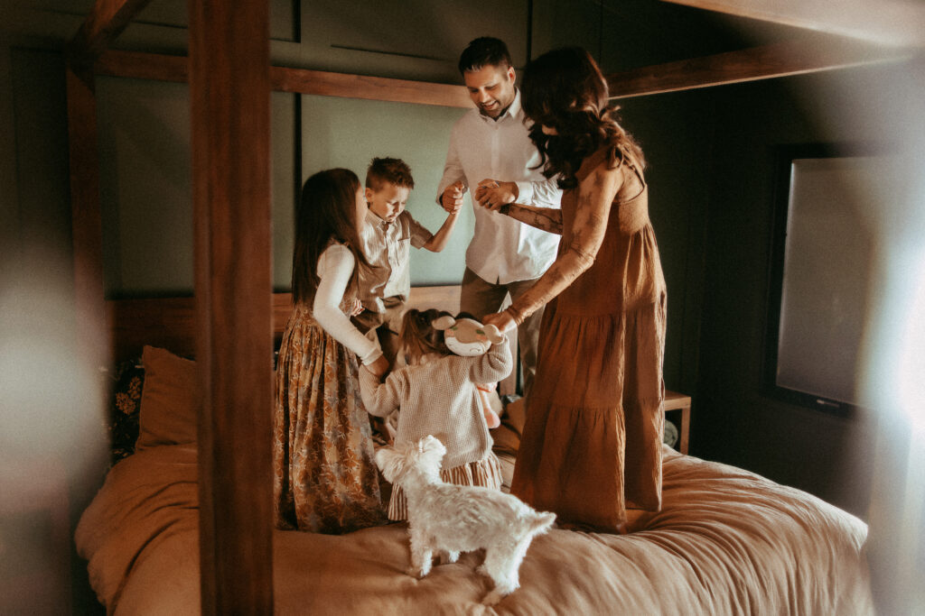 Family dancing on the bed.